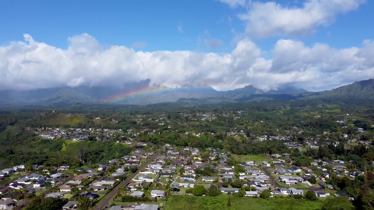 vista aérea cinematográfica con arco iris en el cielo nublado en kauai