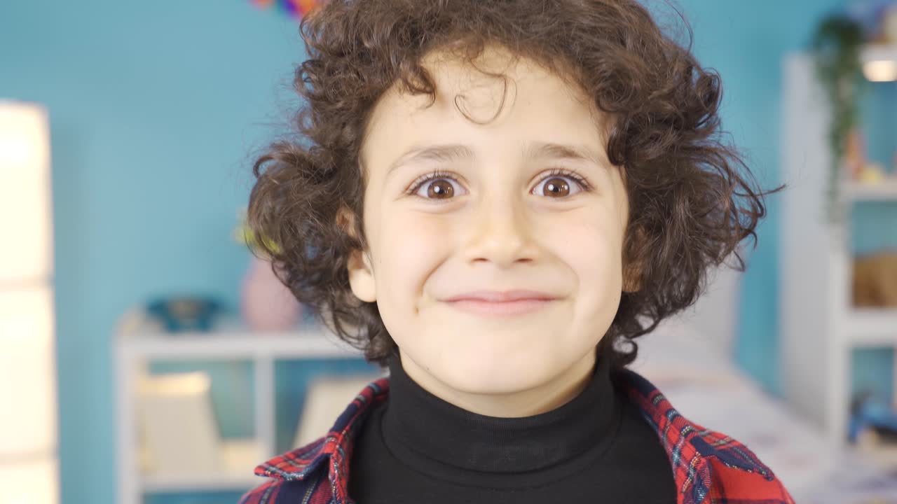 el chico lindo sonríe y sacude la cabeza para estar satisfecho, para gustarle.