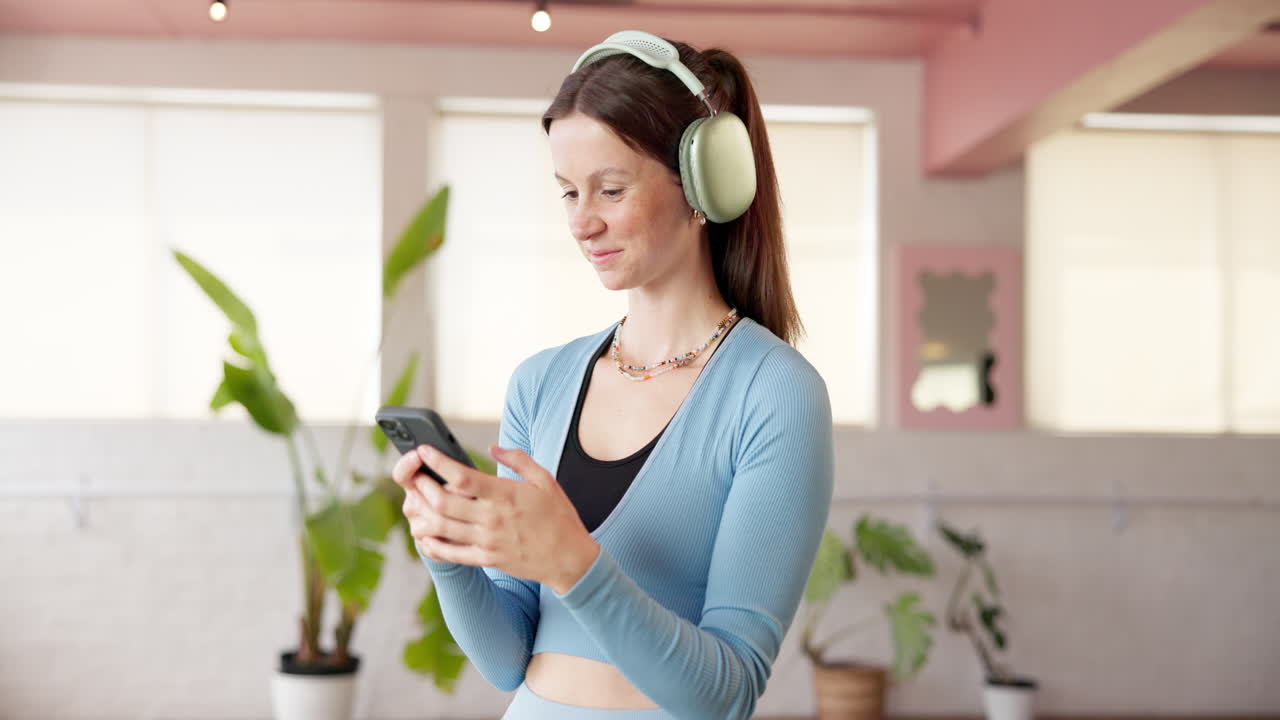 Donna con cuffie che usa il telefono in interni