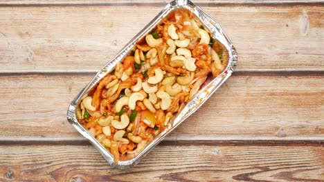 pollo de caju frito en un recipiente de aluminio
