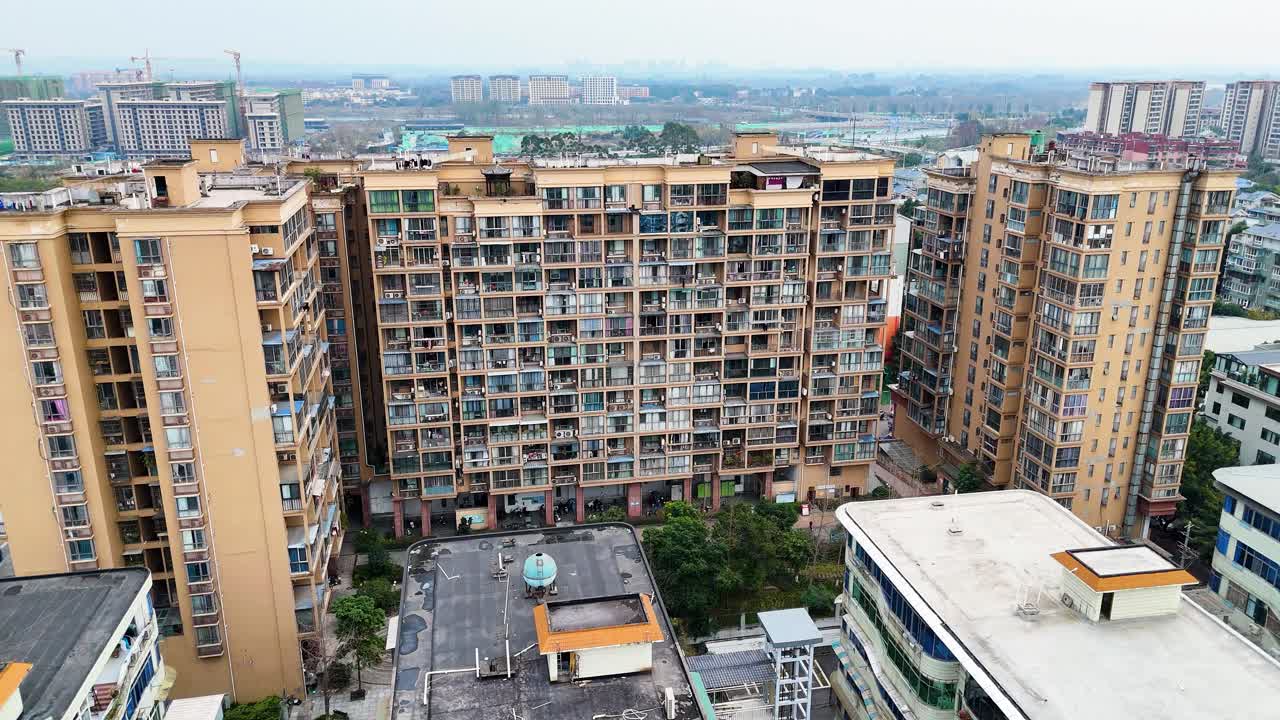Orbiting drone shot of a dense residential area in Xinjin County, Chengdu, An old apartment building and urban development. China