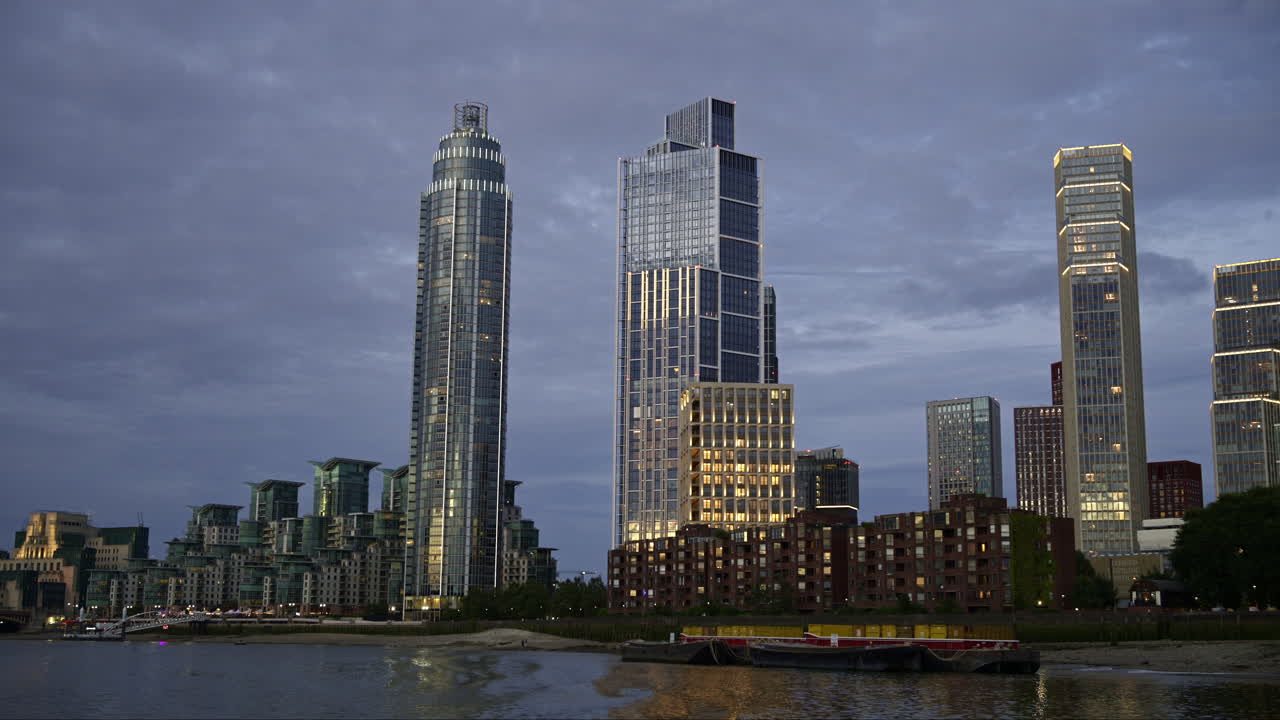 View of London from a floating boat on the Thames River at sunset, United Kingdom. Skyscrapers and modern buildings located along the river