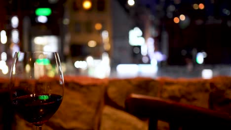 wine glass on table with blurred city backdrop