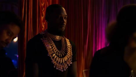 man in gold jewelry at a nightclub