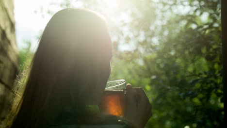 Girl-drinking-hot-tea-outdoor-at-sunset