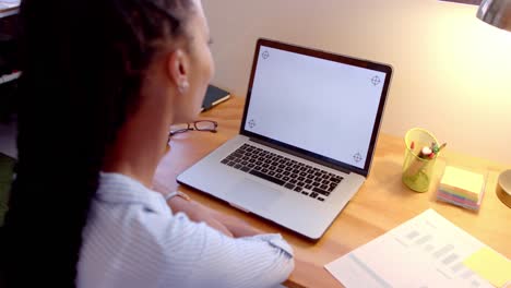 mujer de negocios afroamericana que usa una computadora portátil con espacio de copia en la pantalla en la oficina, cámara lenta