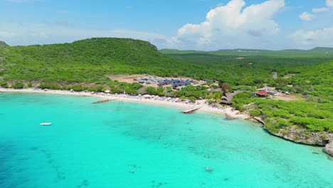 wide angle aerial orbit rises above playa porto mari on sunny day in curacao