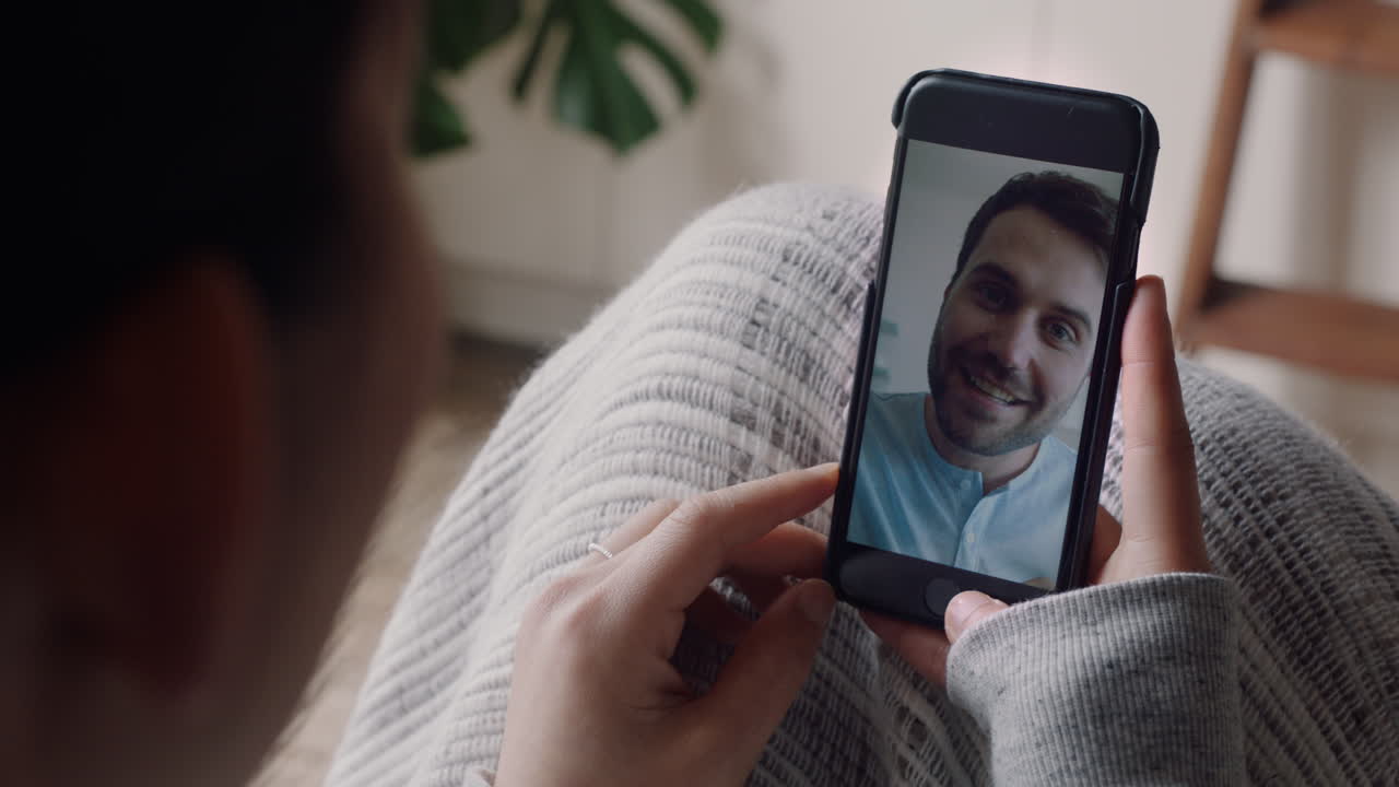 mujer joven teniendo video chat usando smartphone en casa hablando con su novio disfrutando de la conversación compartiendo estilo de vida comunicándose con el teléfono móvil