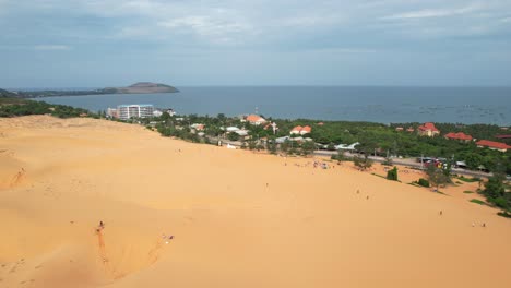 Antena-De-Dunas-De-Arena-Del-Desierto-Cerca-De-Una-Carretera-A-Lo-Largo-Del-Océano-En-Mui-Ne-Vietnam