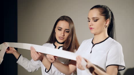 Two young doctors discuss the results of the electrocardiogram. ECG in hand.