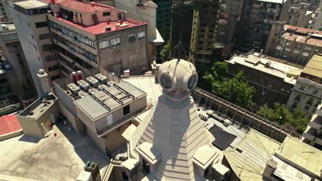 Toma-Aérea-En-órbita-Sobre-La-Azotea-Y-La-Torre-Del-Edificio-Ariztía,-Primer-Rascacielos-En-Santiago-De-Chile.