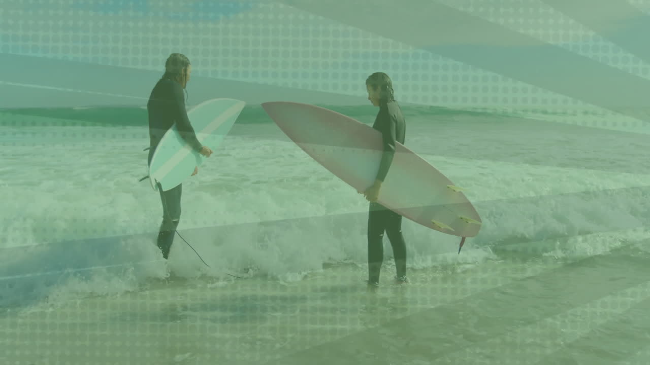 Two surfers standing holding surfboards on beach, displaying animated fitness graph and wave icons