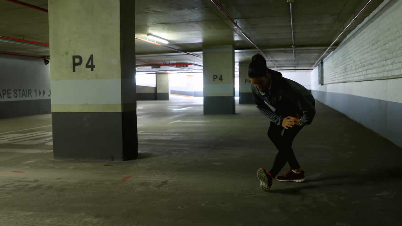 Woman exercising at underground car parking lot 4k