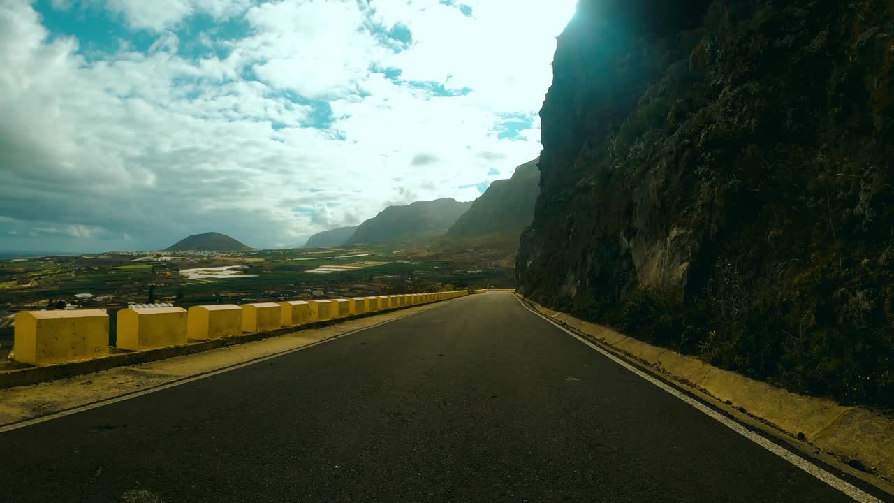 Driving along a road on the side of a mountain in Punta de Teno in Tenerife.