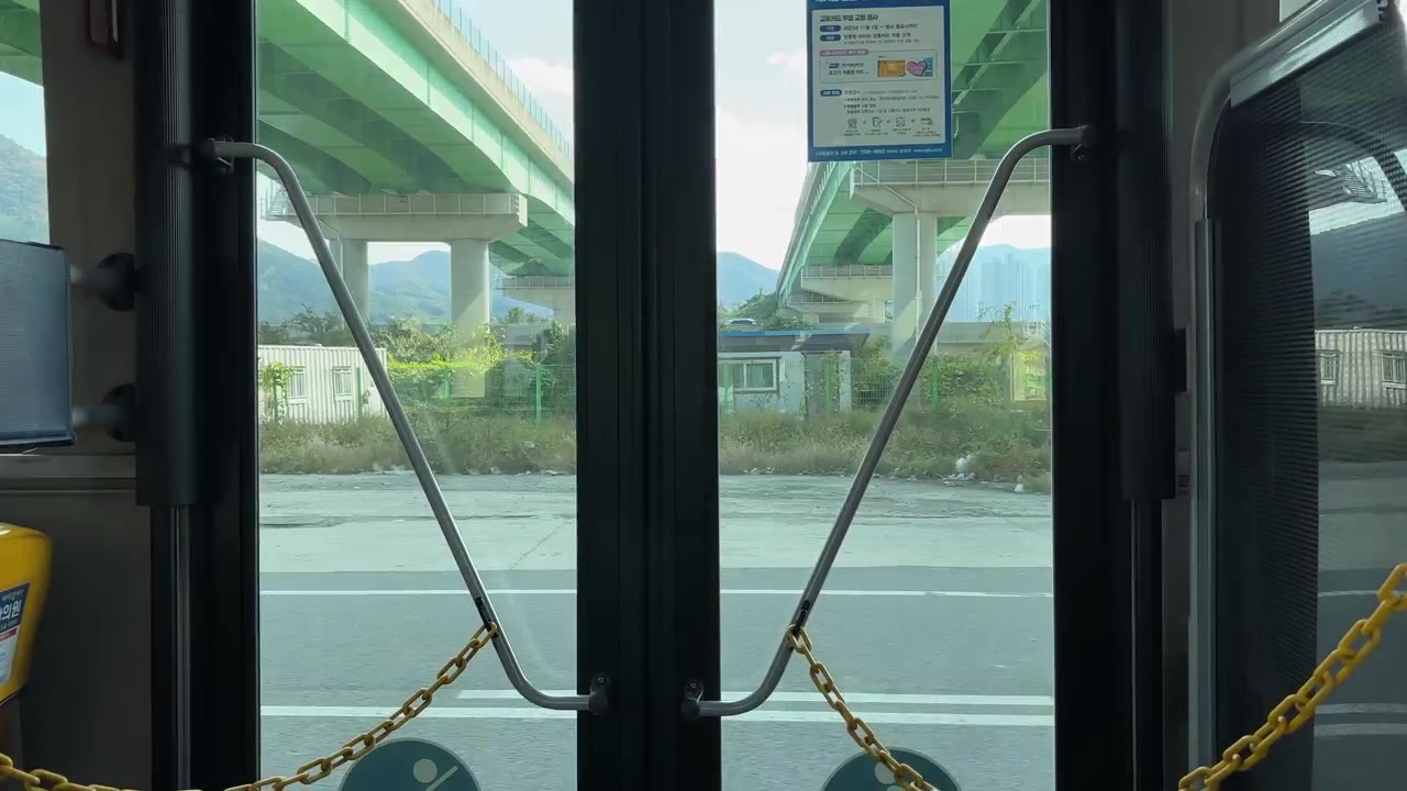 Vista dall'interno di un autobus in viaggio attraverso Gyeongju, Corea del Sud, che mostra paesaggi diversi.