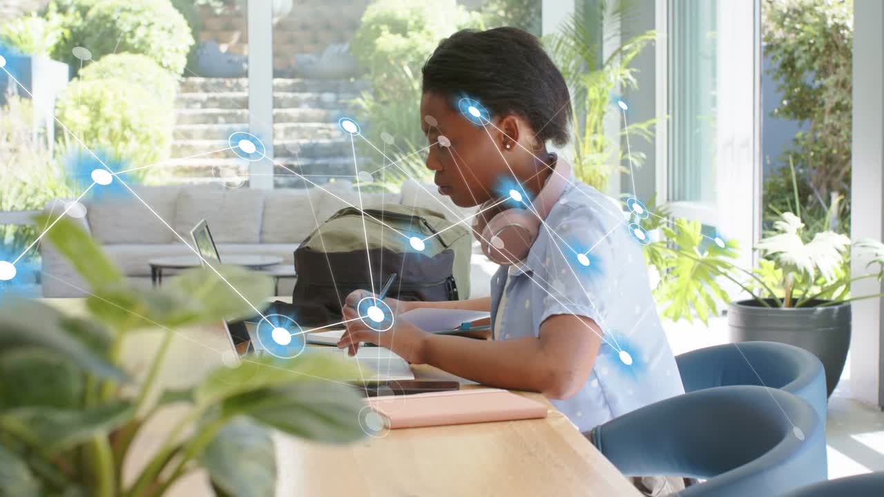 Student typing on laptop using stylus, initiating glowing nodes forming tech network around hands