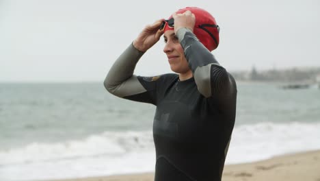 jonge vrouw in wetsuit die een veiligheidsbril draagt en aan het opwarmen is