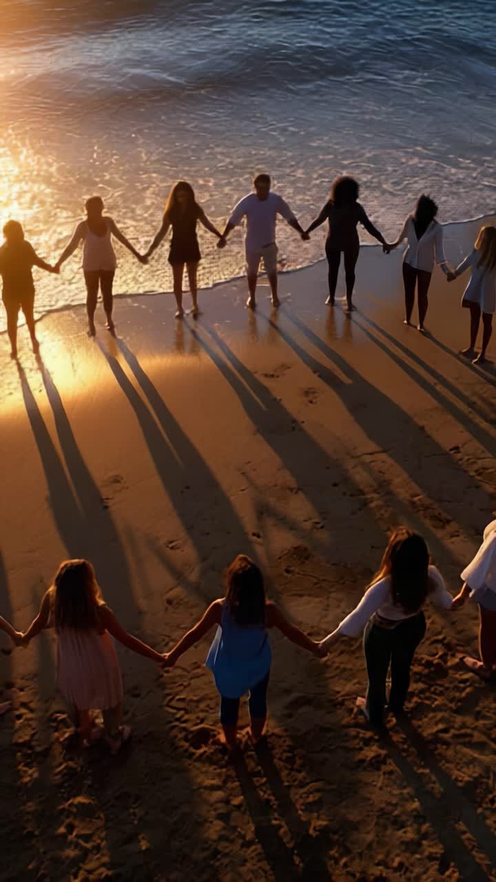 A Group of Friends Standing Hand in Hand at Sunset on the Beach, Creating Shadows on the Sand, Embracing Togetherness and Connection