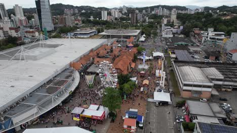 Drone-video-of-the-Oktoberfest-party-in-Vila-Germânica,-outdoor-area-with-the-amusement-park,-decorations-and-people,-city-of-Blumenau,-Santa-Catarina,-Brazil