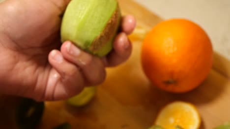 peeling a kiwi next to an orange