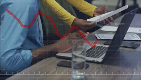 animación de diagramas y procesamiento de datos sobre colegas biraciales usando computadora portátil en la oficina