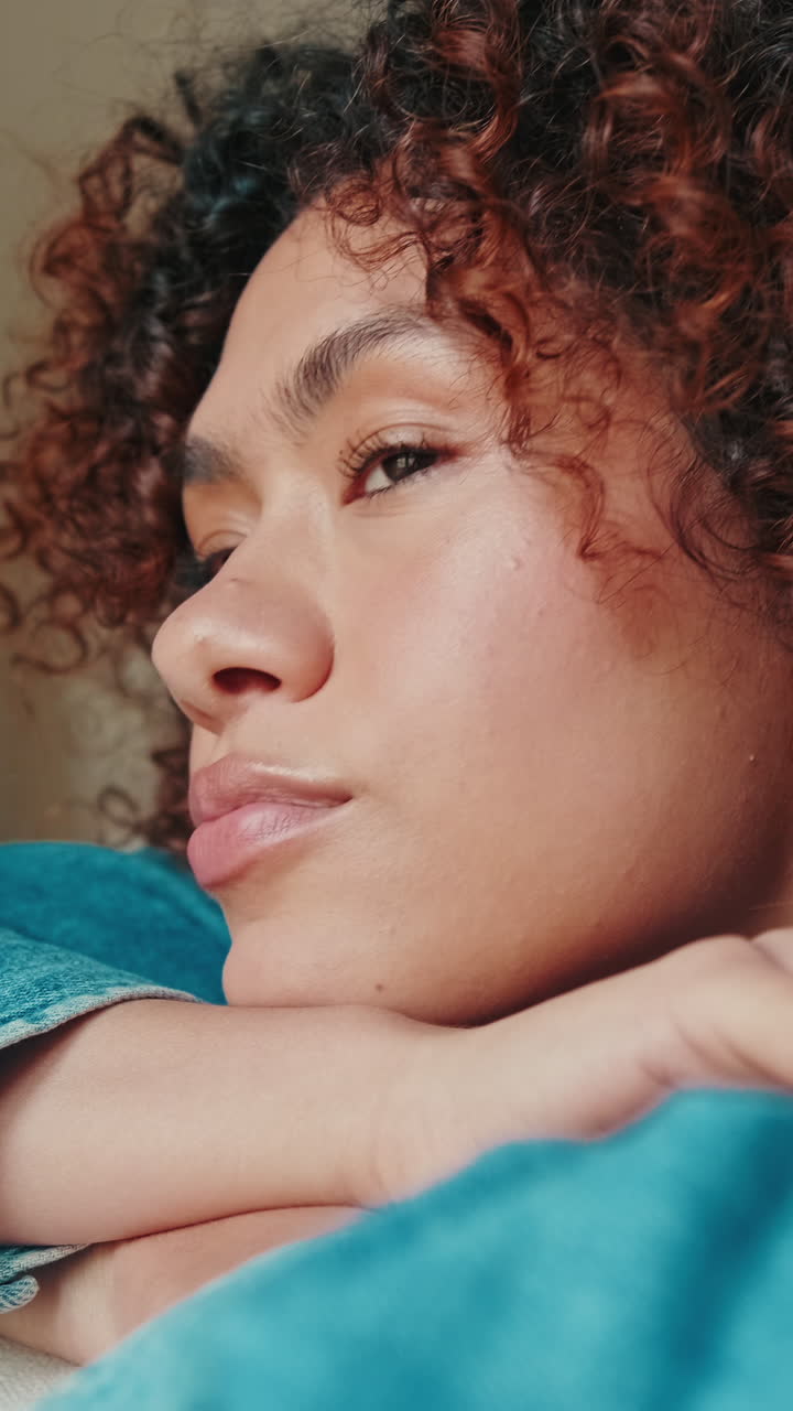Close Up of Thoughtful Young Woman with Curly Hair Resting