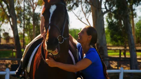 Mother-assisting-daughter-during-horse-riding-4k