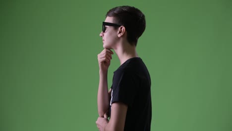 young handsome iranian teenage boy against green background