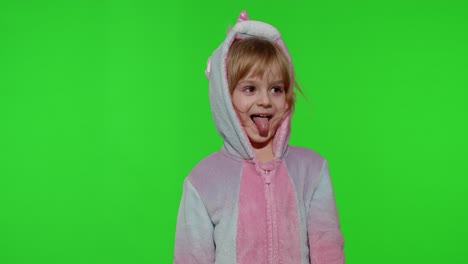 Child-girl-in-unicorn-pajamas-making-silly-funny-faces,-fooling-around,-showing-tongue-on-chroma-key