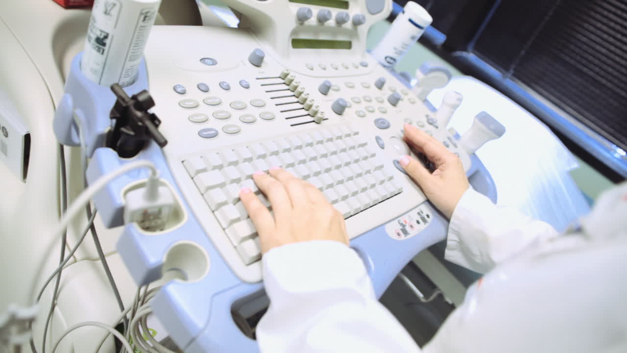 A nurse inputs data on a computer sonogram after she's worked on a patient.