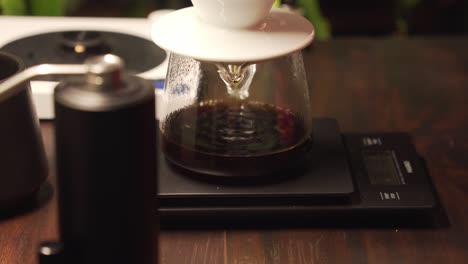 black coffee slowly drip into glass carafe through ceramic dripper and filter