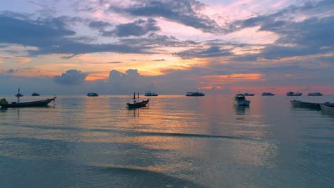 beautiful sunset over the ocean with boats anchored