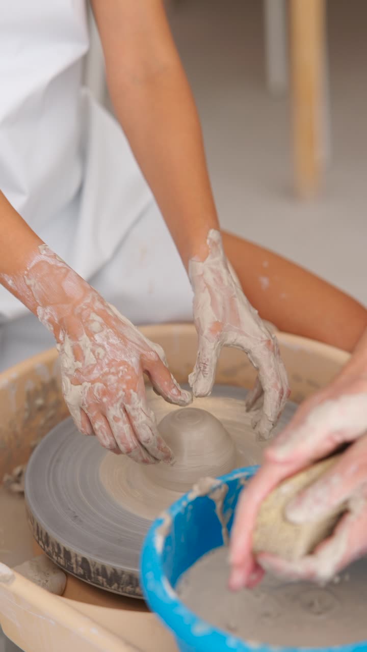 Hands shaping clay on a pottery wheel during a ceramics workshop