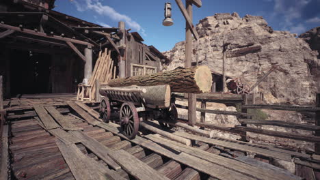 historic wooden log cart in an old western mining town under clear sky