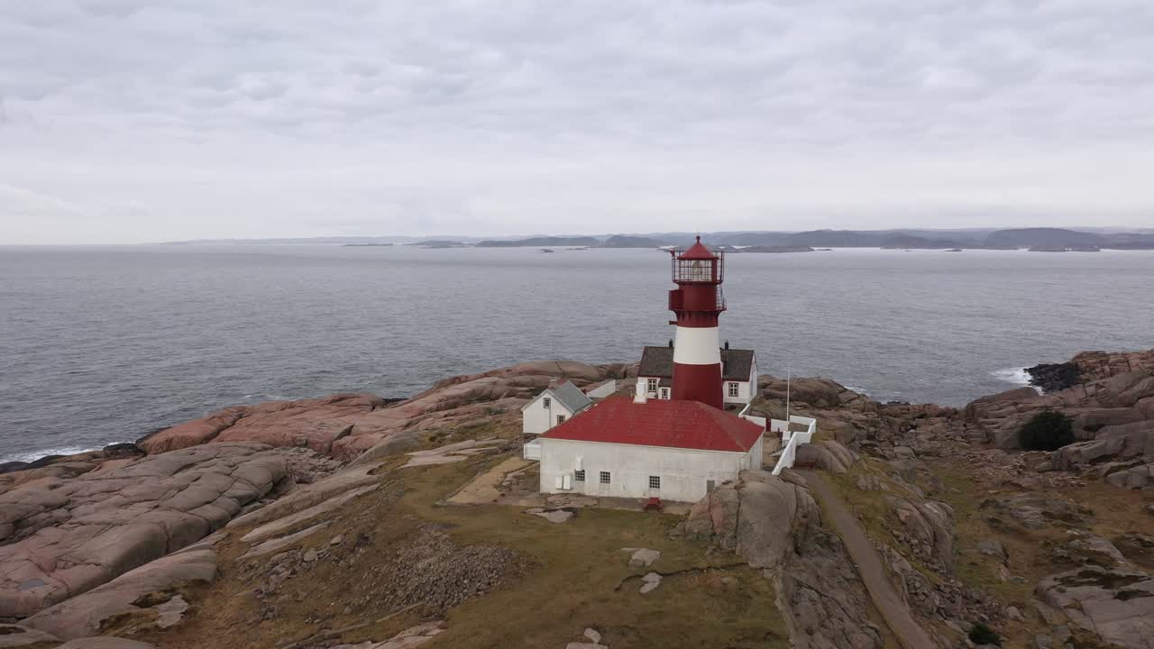 hermoso faro con cabaña de fareros en ryvingen en el sur de noruega - ubicación idílica en la costa sur de noruega - vuelo aéreo hacia la torre del faro y pasando muy cerca