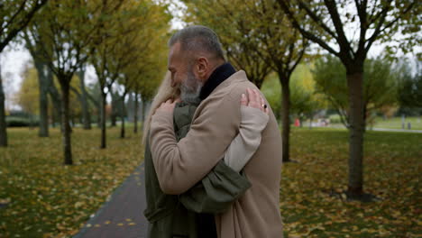 wide shot of close up adult couple hugging with enjoyment each other in park.