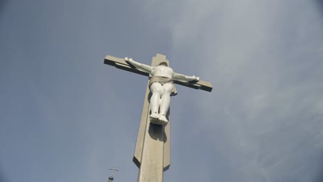 jesus statue waching from below outside with blue sky