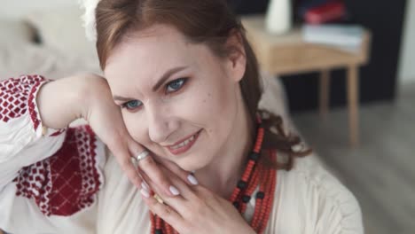 portrait features a beautiful young woman in authentic ukrainian embroidered attire posing with flowers in her hair in front of the camera