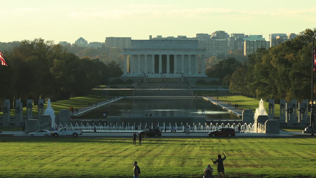 Washington DC, USA. Wide View of Lincoln Memorial Building, Reflective Pool and People on Meadow of National Mall Park on Golden Hour Sunlight, Static.