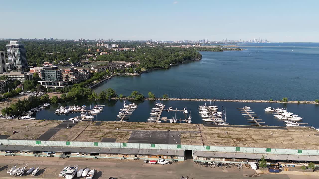 Slow Right to left shot of the parked boats by the water, seeing a lot of buildings of Port Credit, Ontario, Canada during the afternoon