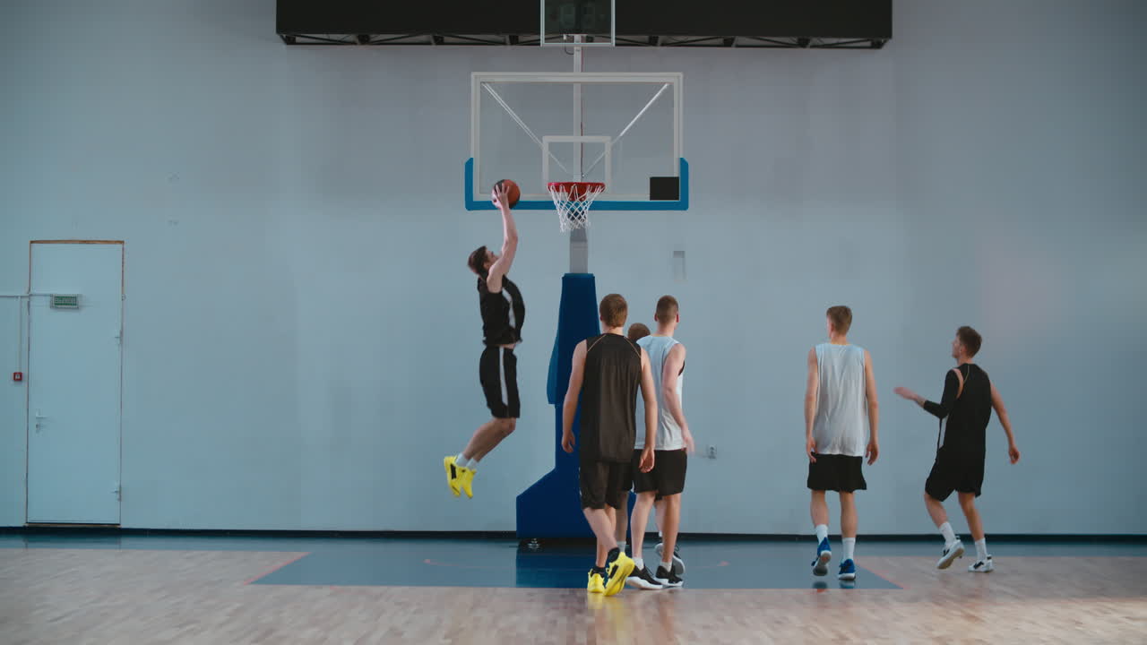 High school team playing basketball indoors, practicing combinations and drills. 4K UHD