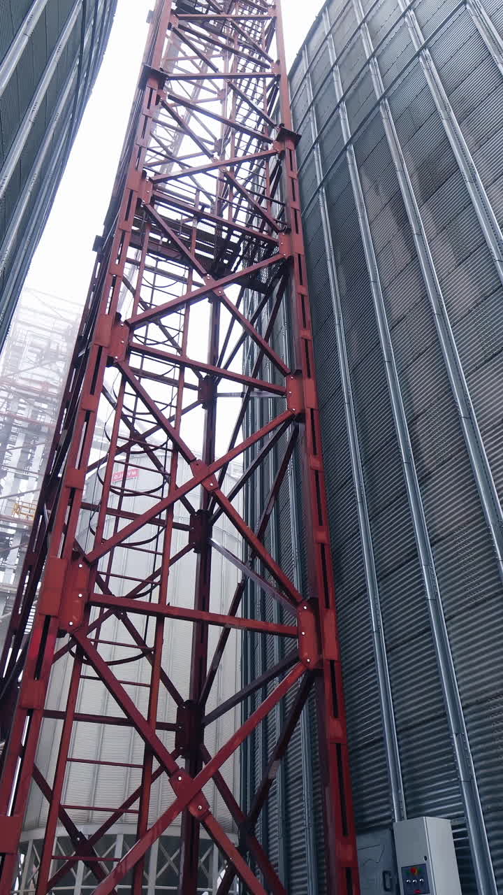 Big steel elevator construction storage. Industrial agriculture farming equipment. Vertical video