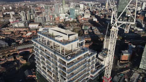 Vuelo-De-Drones-Aéreos-De-4k-60fps-Alrededor-De-Un-Edificio-De-Torre-En-Construcción-Con-Vista-Al-Centro-De-La-Ciudad-De-Manchester-Con-Altos-Rascacielos-En-El-Fondo