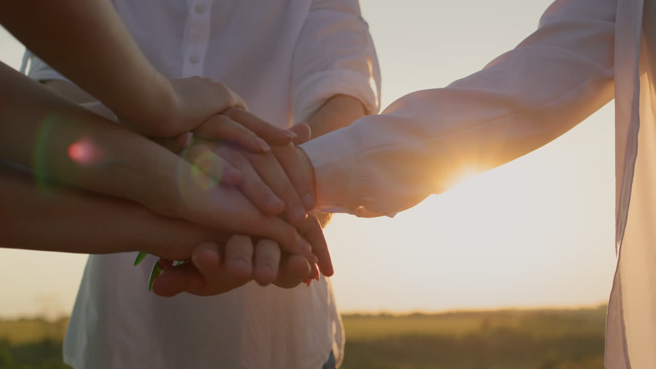 한 무리의 사람들이 손바닥을 서로 위에 놓고 그들을 올립니다. 팀워크 개념