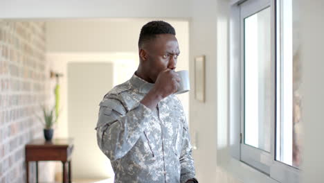 young african american soldier holding a coffee mug at home, with copy space