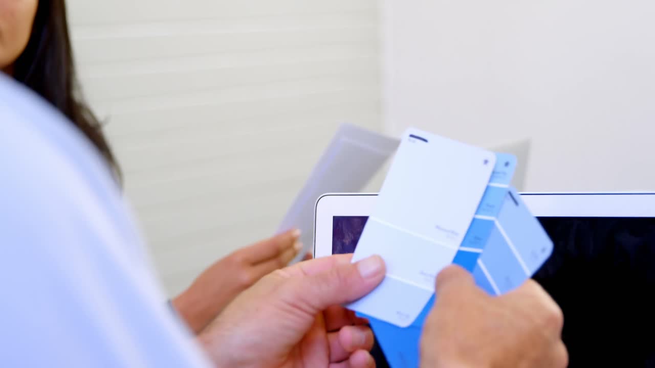 Dirigente che controlla una cartella colori in ufficio 4k