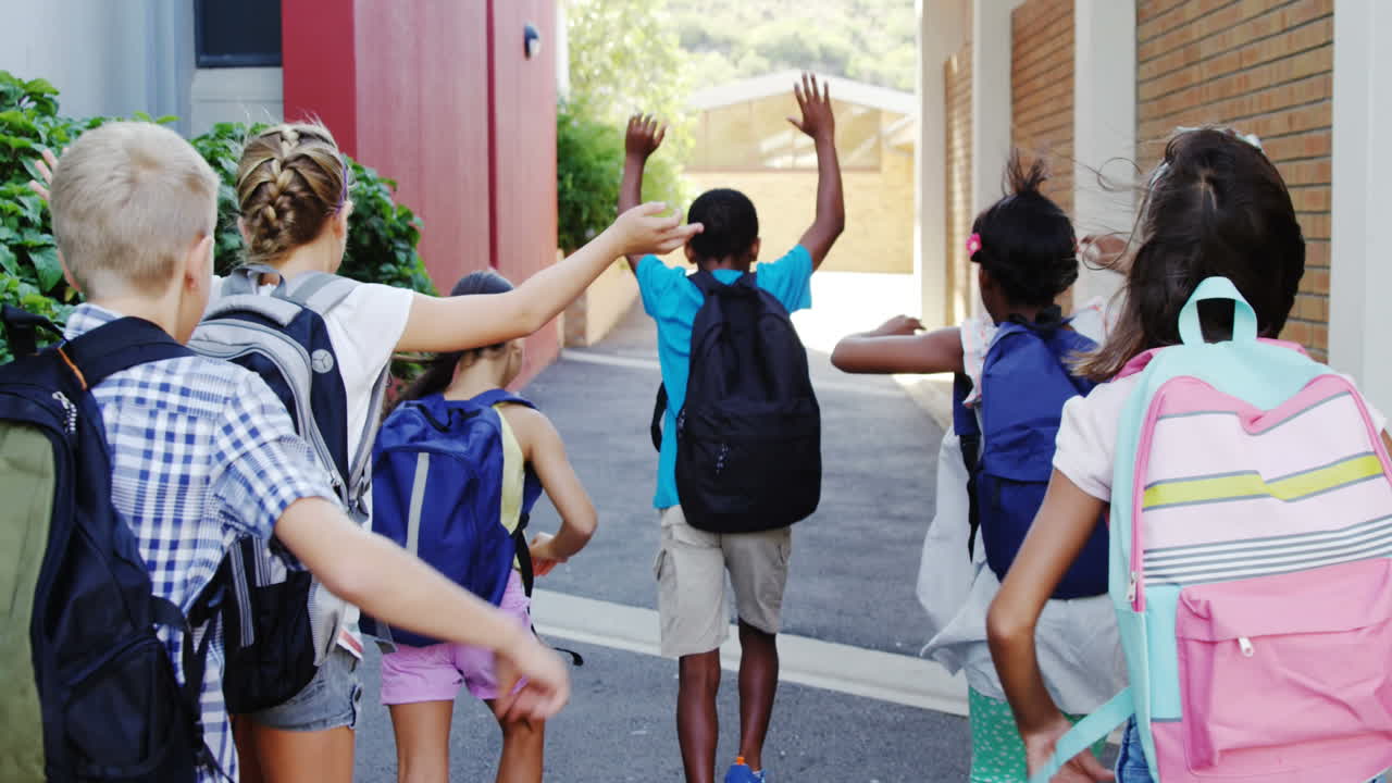 학교 건물의 아이콘이 학교에서 달리는 학생들의 그룹의 뒷면으로 움직이고 있습니다.