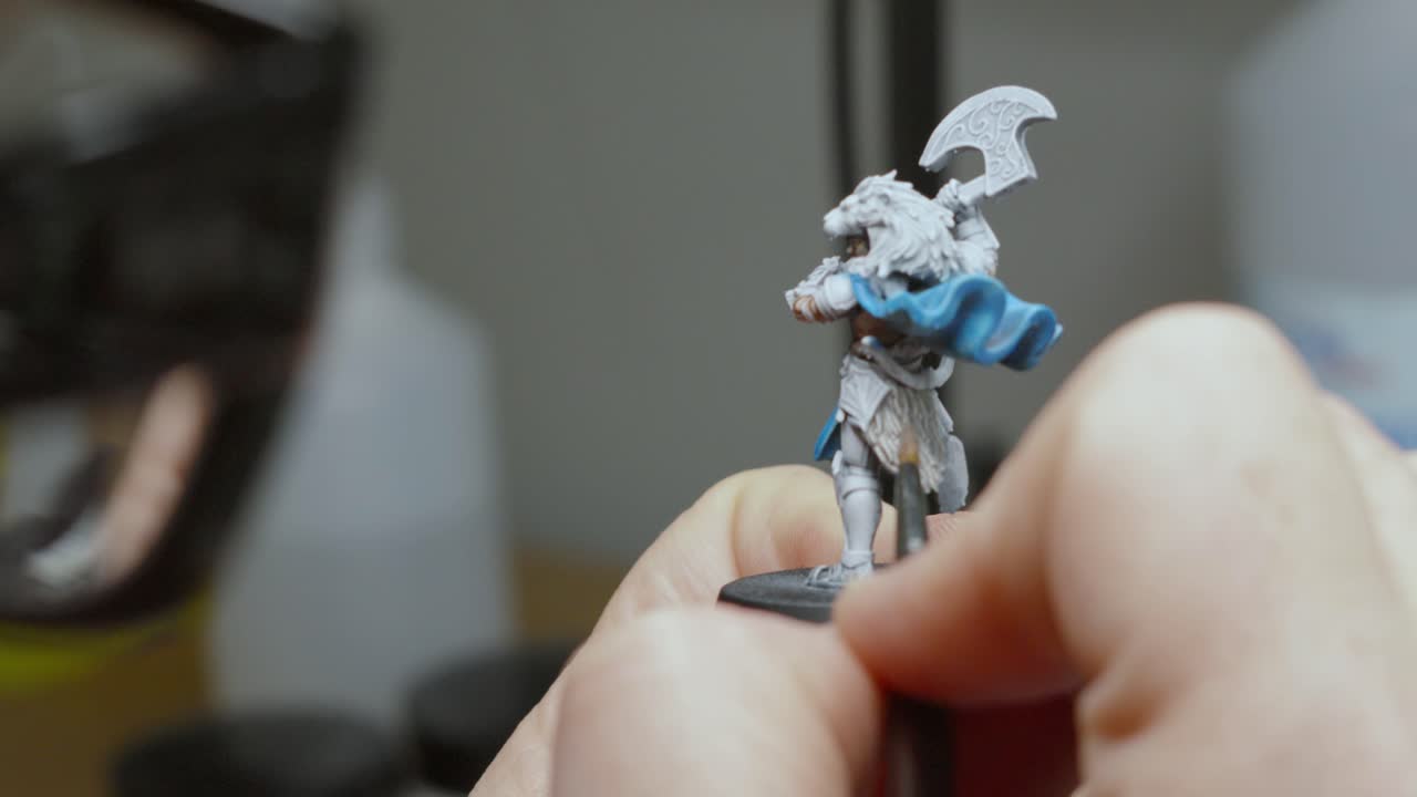 Close Up of Artist Painting Fantasy Miniature Model Details with Shallow Depth of Field and Glasses of Person Visible in Slow Motion 4K