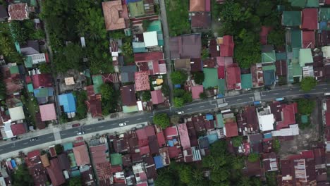 top down drone shot of philippine provincial highway with cars, surrounded by trees and houses