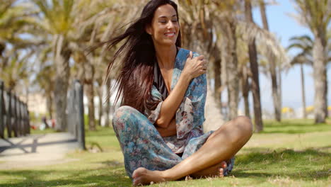 attractive lady sitting on ground hugging herself